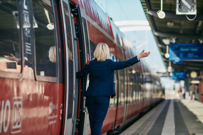 Eine Schaffnerin weißt den Lokführer darauf hin, dass der Regionalzug losfahren kann.